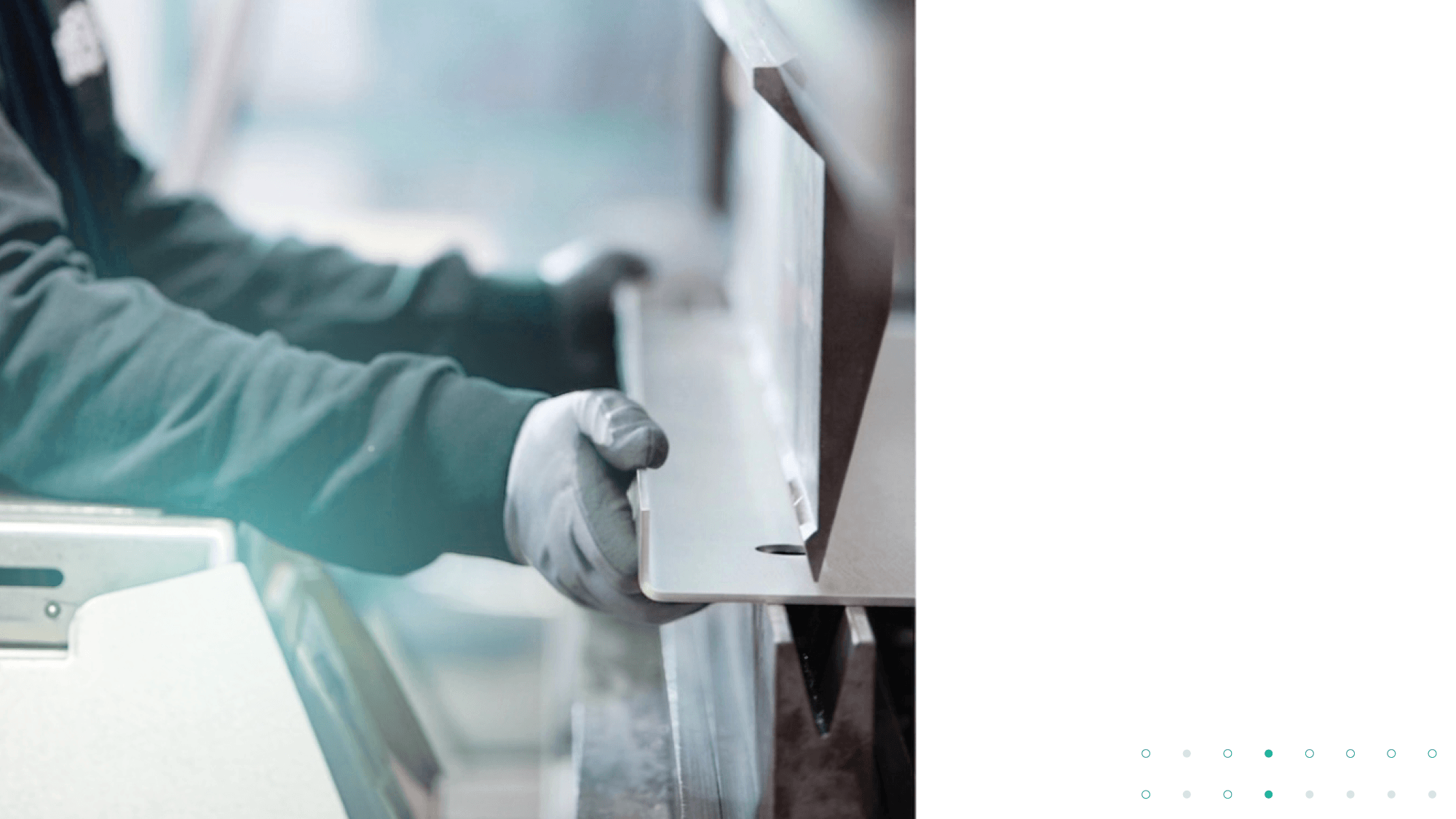Hände mit Schutzhandschuhen führen ein Metallblech in eine Kantbank ein.