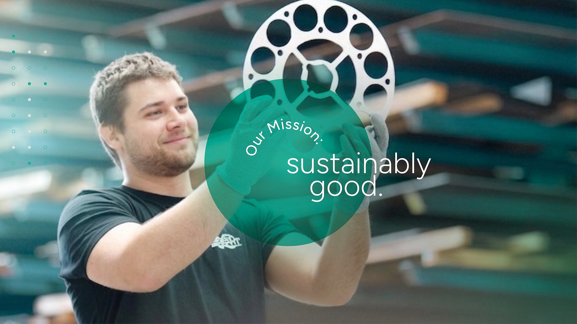 Sustainable commitment in metal processing Worker in a factory holding a round metal part with holes, overlaid with the text Our Mission: sustainably good.