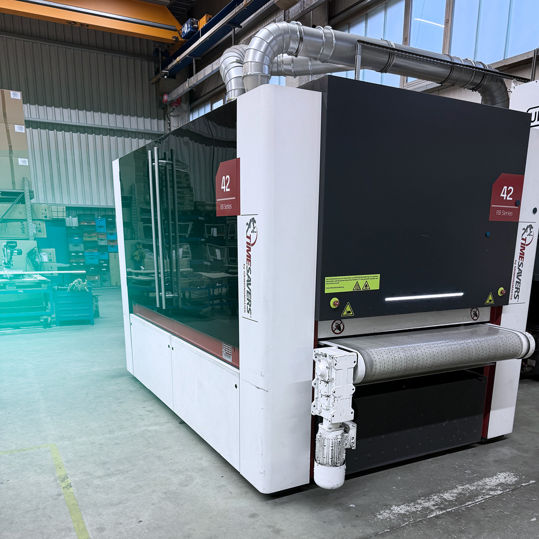 Industrial Timesavers 42 series grinding machine in workshop with conveyor belt