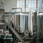 Edelstahltanks und Brauereianlage in einer Fabrikhalle