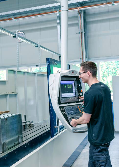 Auszubildender bedient eine CNC-Laserschneidanlage